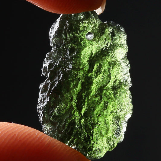 Close-up of green polished crystal pendant in geometric shape