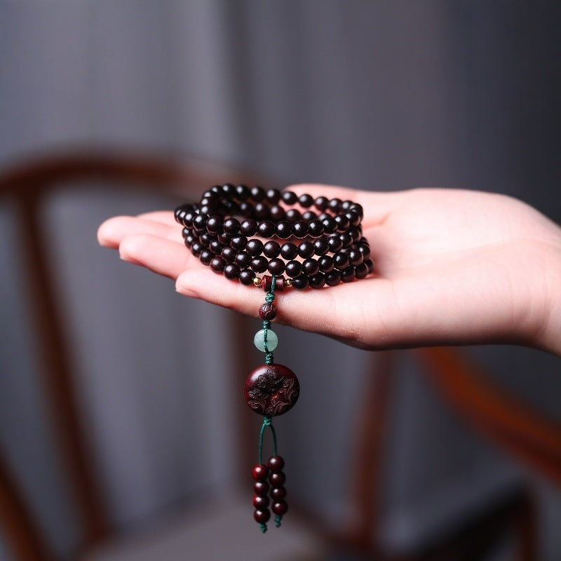"Prosperity talisman bracelet with jade and red beads, crafted for wealth and protection."